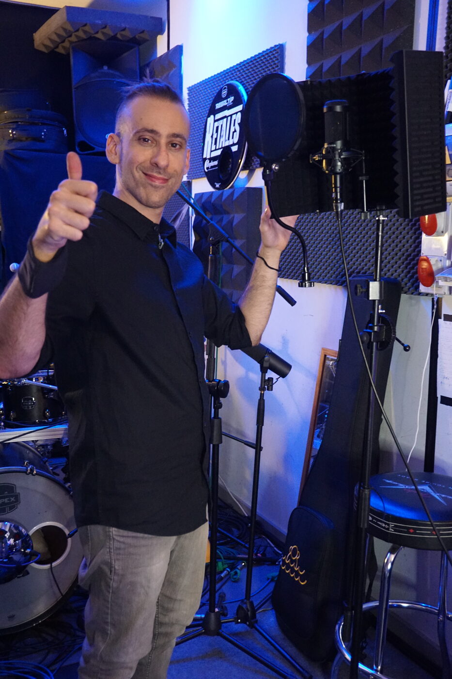 Alberto en su estudio, de pie junto a la cabina, con el pulgar hacia arriba